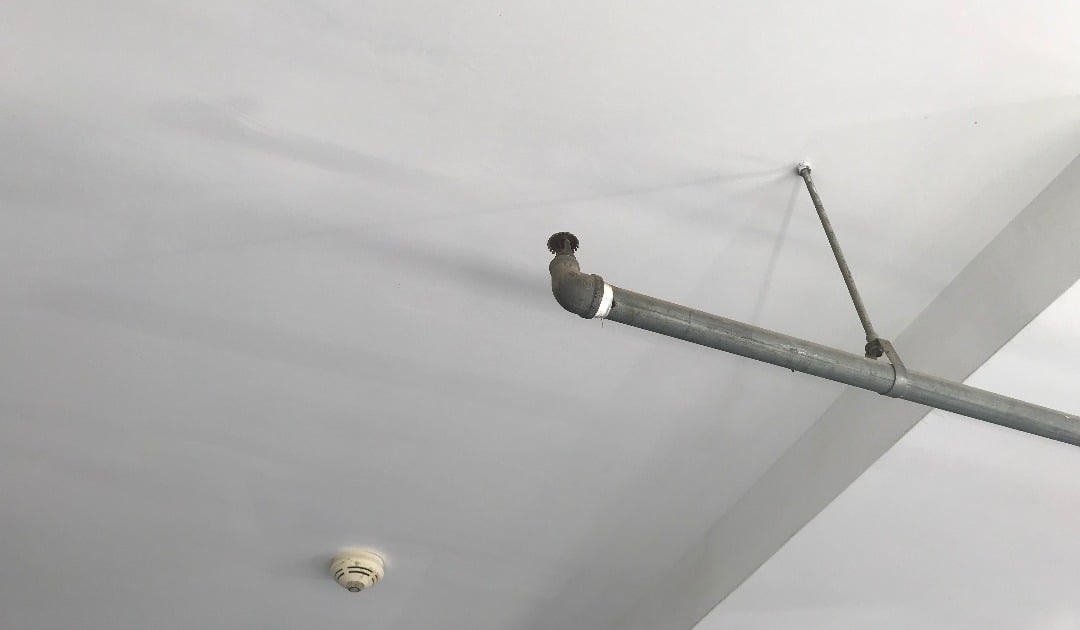 Featured image: Different types of fire alarm systems on white wall - Read full post: Different Types of Sprinkler Systems Explained