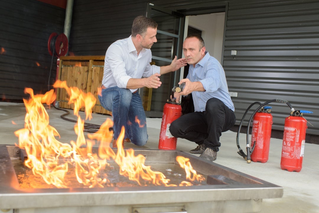 Featured image: Two men testing fire extinguishers with flames - Read full post: Ultimate Guide to Fire Extinguishers: Testing, Inspections, Maintenance